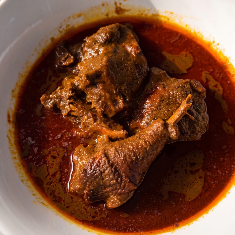 Gros plan sur une sauce graine, bœuf et pilon de poulet dans la sauce de noix de palme, au restaurant africain Sepela