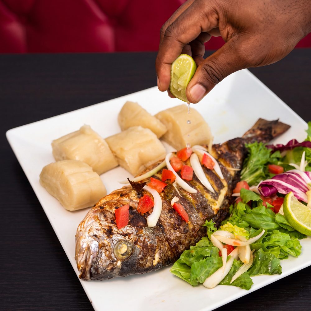 Photo d'un tilapia braisé, oignon, tomate, manioc et citron vert, au restaurant africain Sepela à la Guillotière, Lyon 7
